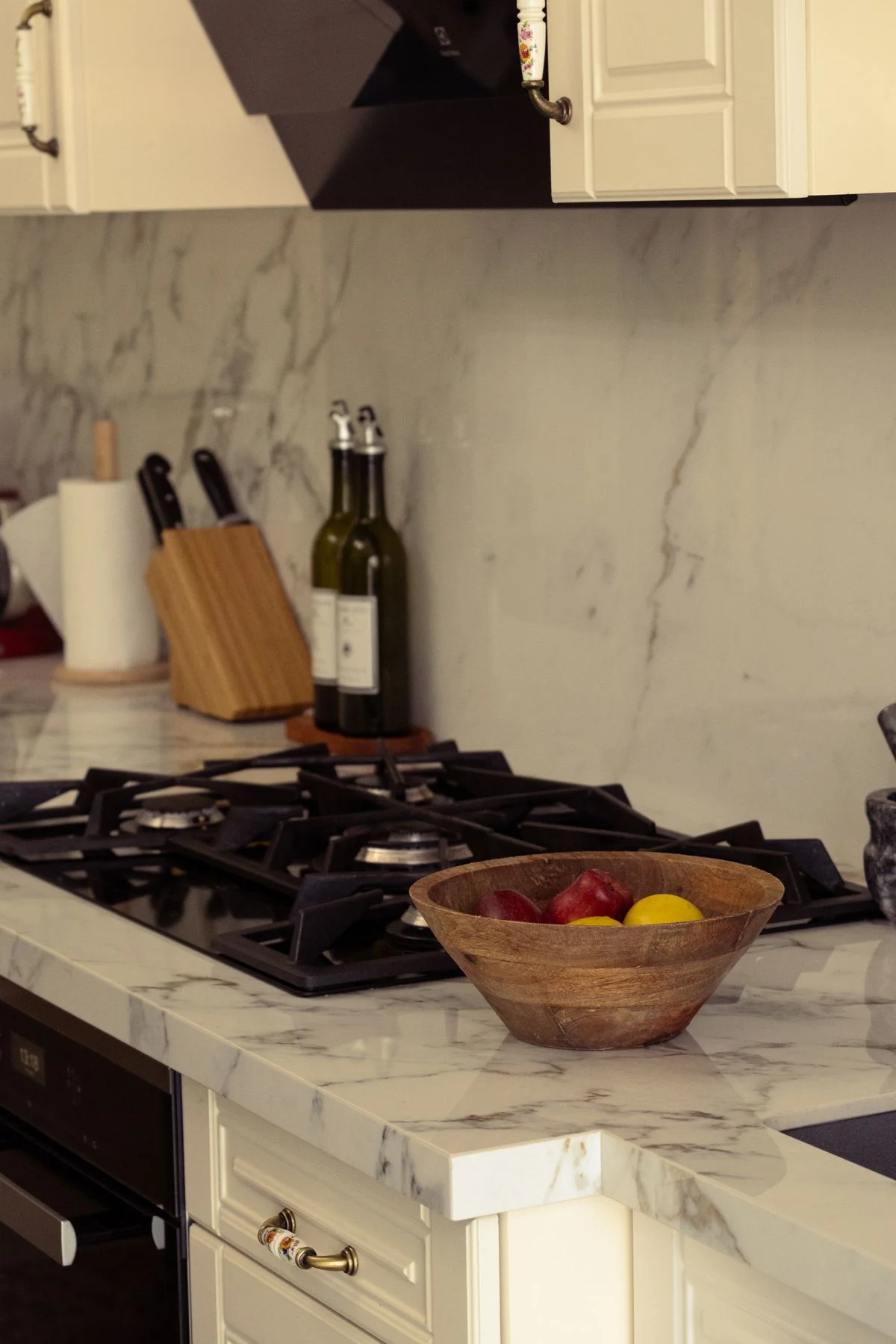 A countertop fruit bowl filled with fresh fruit in a bright kitchen