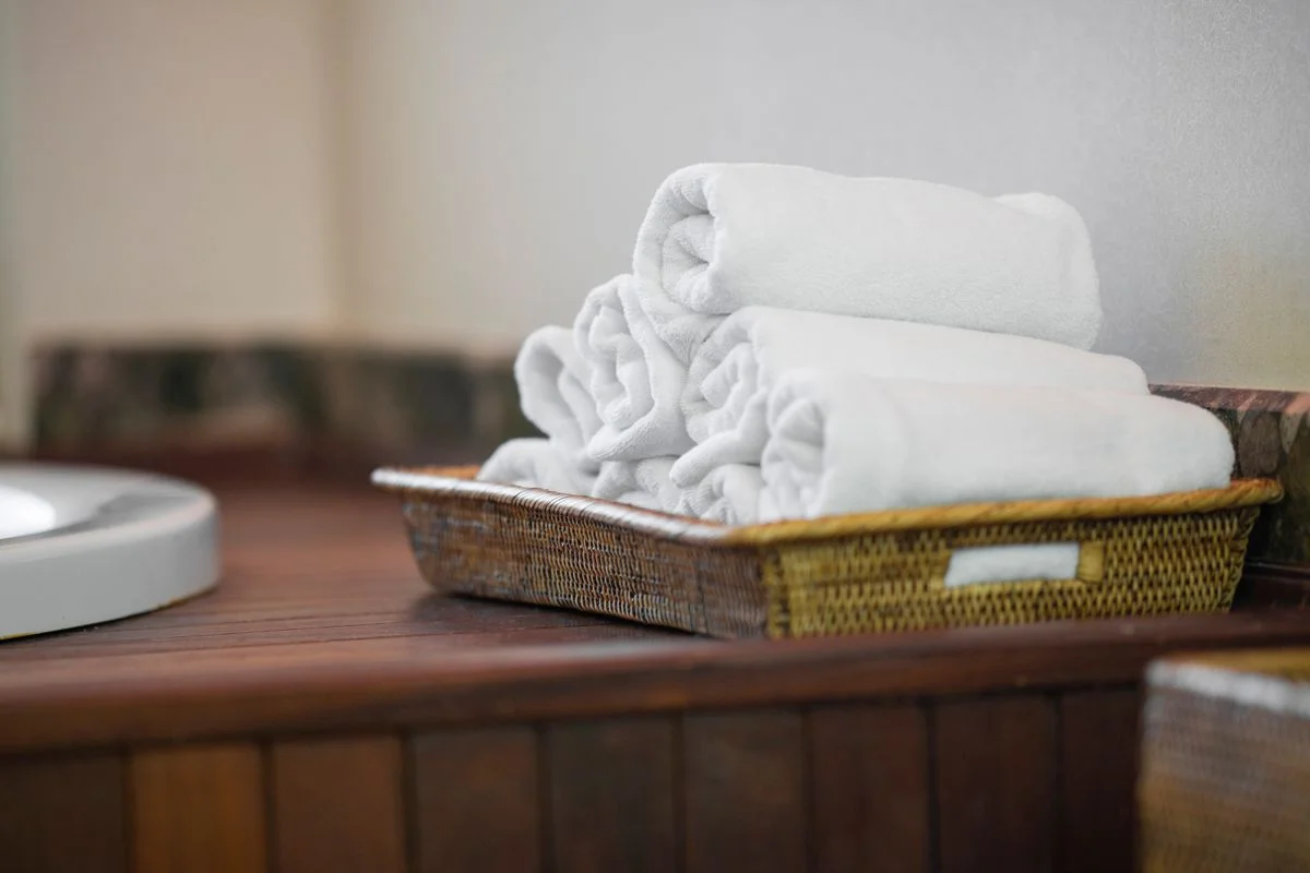 Rolled towels standing upright in an open bathroom basket