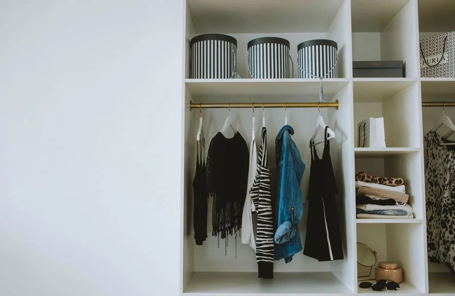 Hanging closet shelf organizer with folded clothes in cubbies