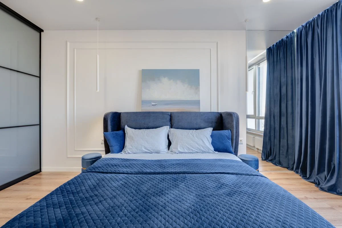 Blue upholstered bed frame and headboard in a bedroom
