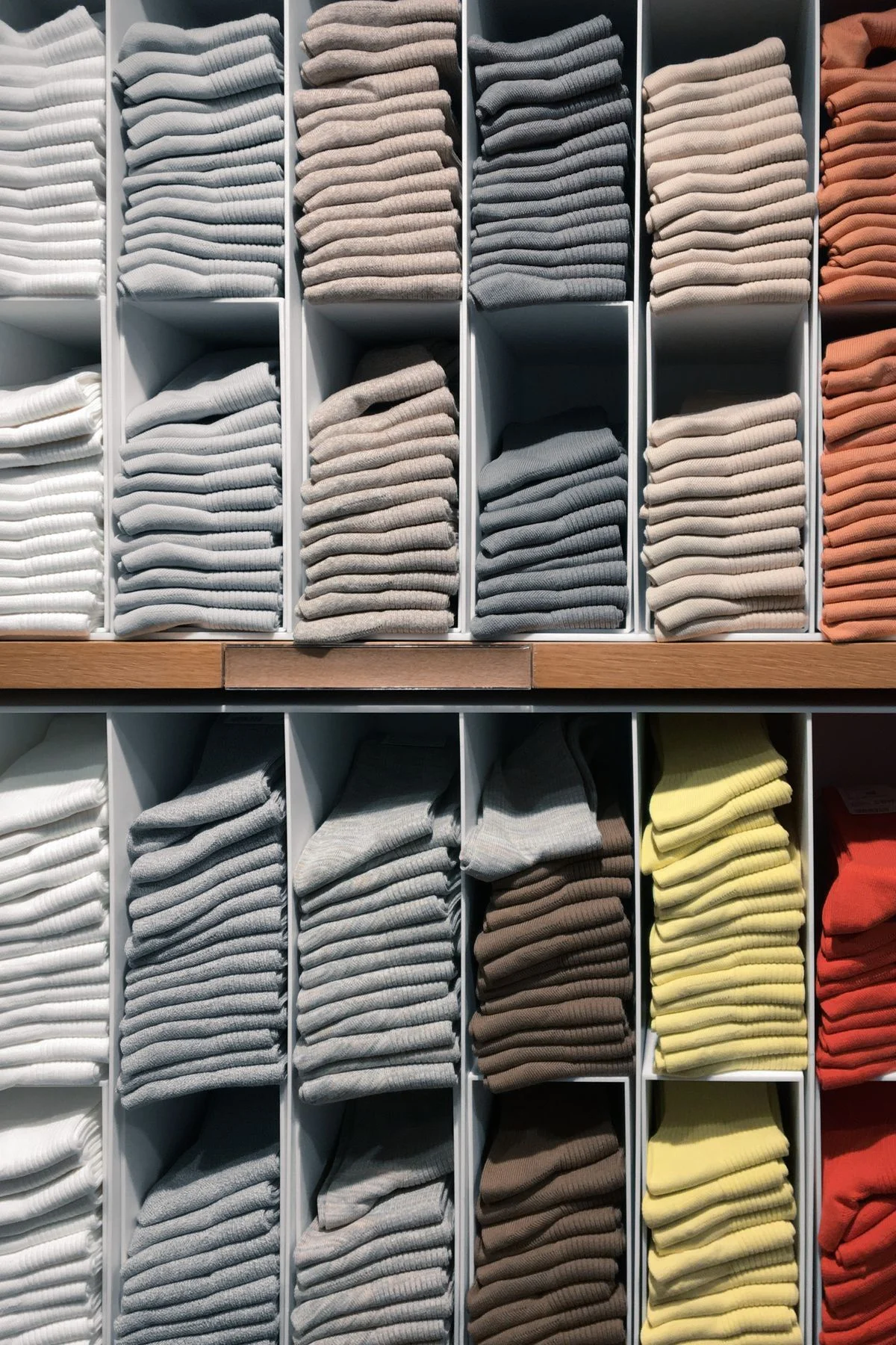 Shelf dividers keeping folded clothes upright in a closet