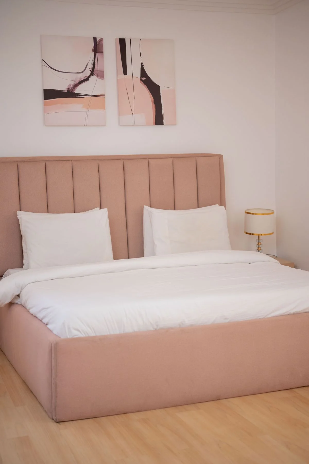 Pink upholstered bed frame and headboard in a bedroom
