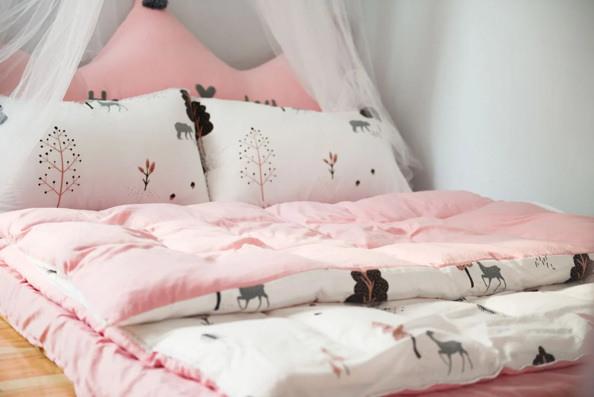 Pink bedding set with layered pillows on a bed