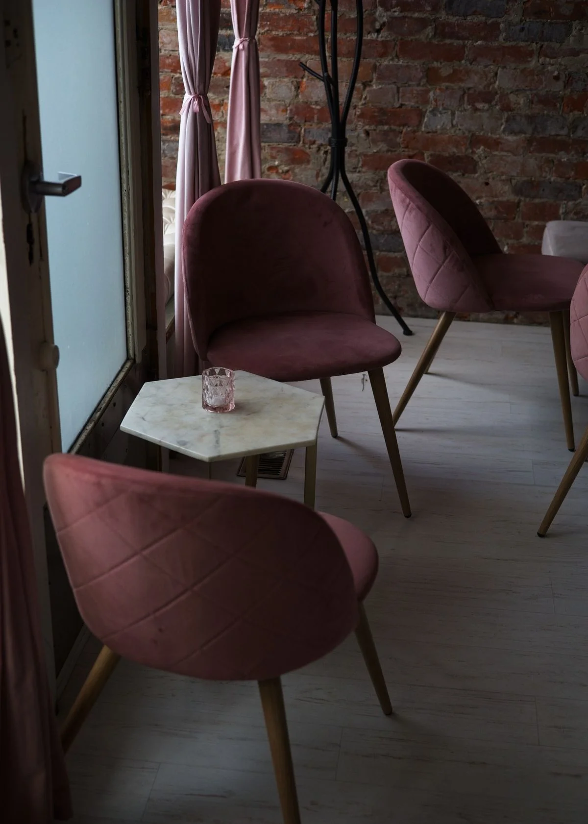 Pink velvet accent chair in a bedroom reading corner