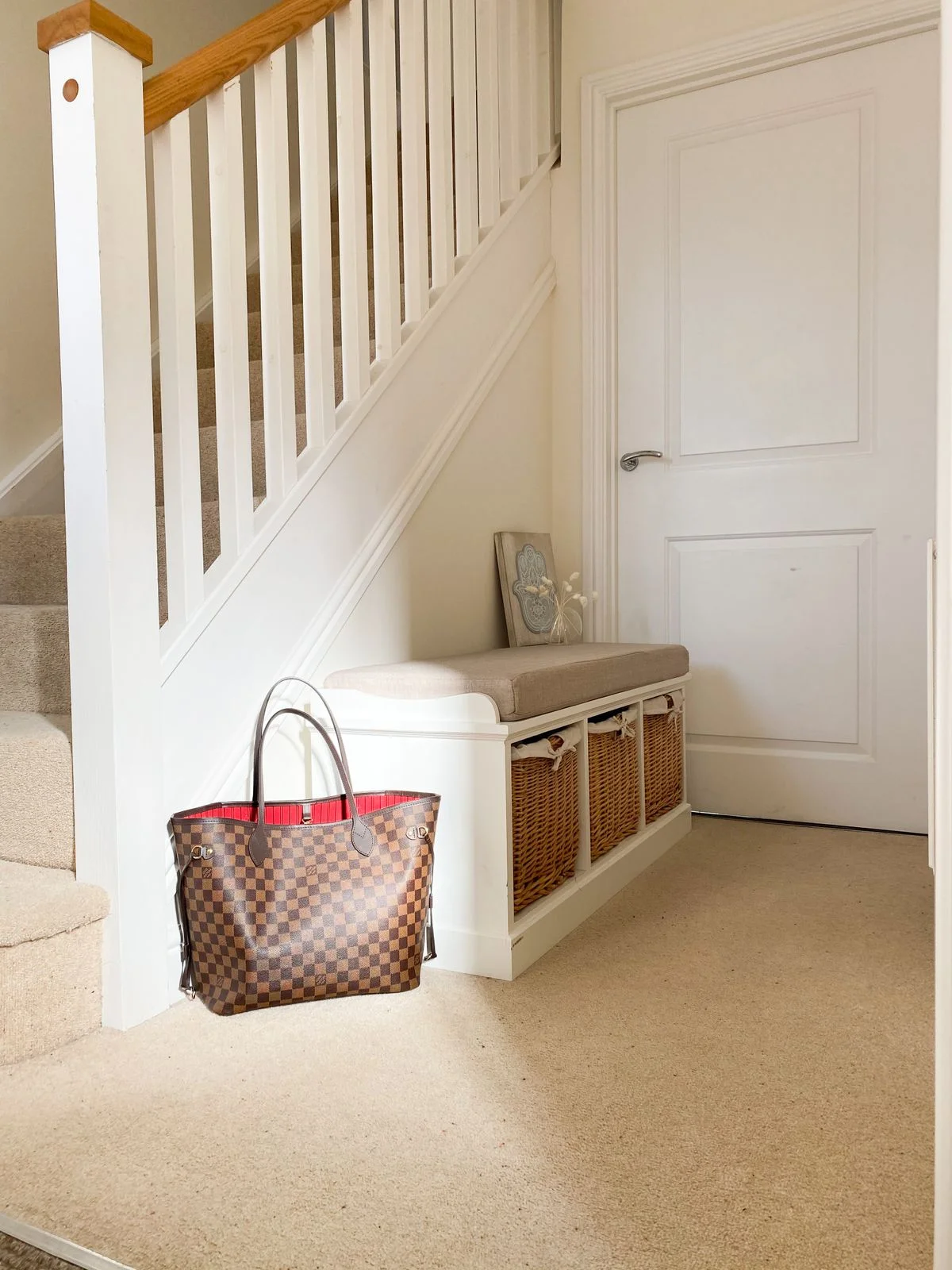 Storage bench on a staircase landing with baskets underneath