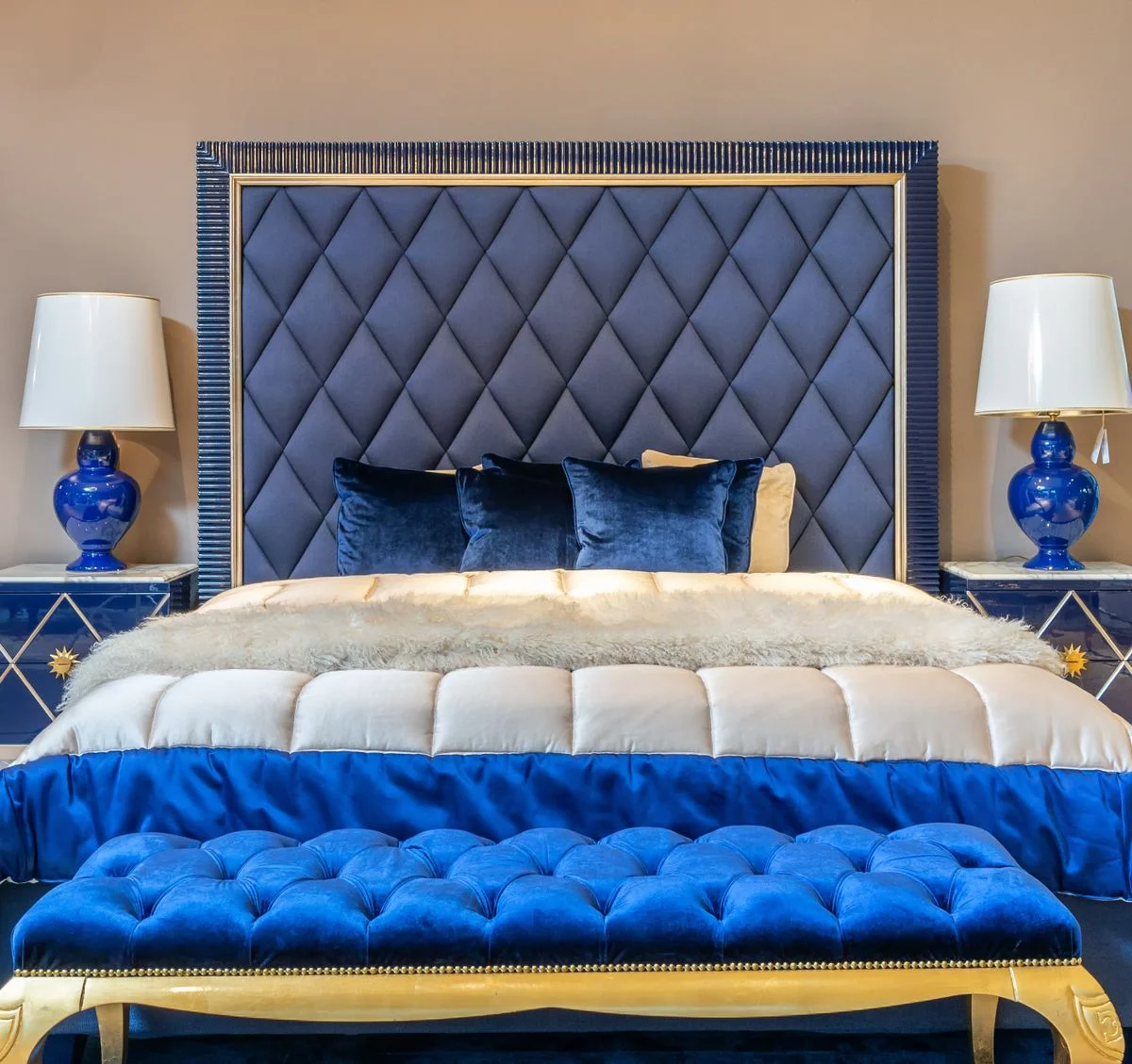 Blue storage bench at the foot of a bed