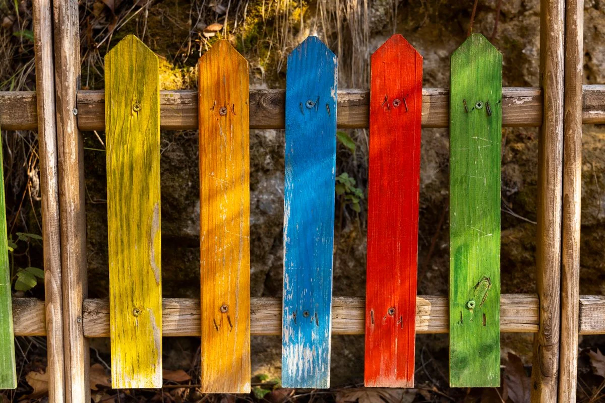 Colorfully painted backyard fence in a garden