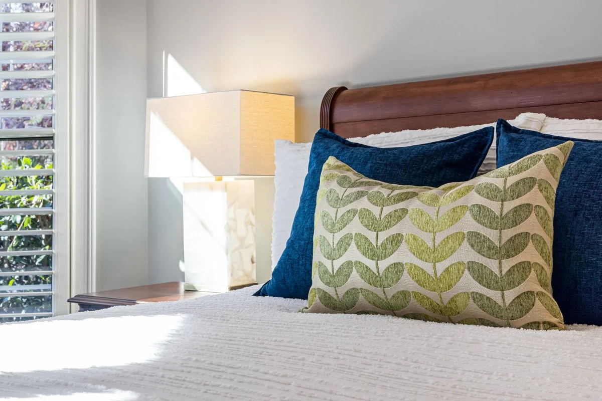 Layered blue throw pillows on a bed
