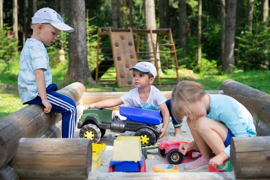 Children playing in a sandbox with built-in storage