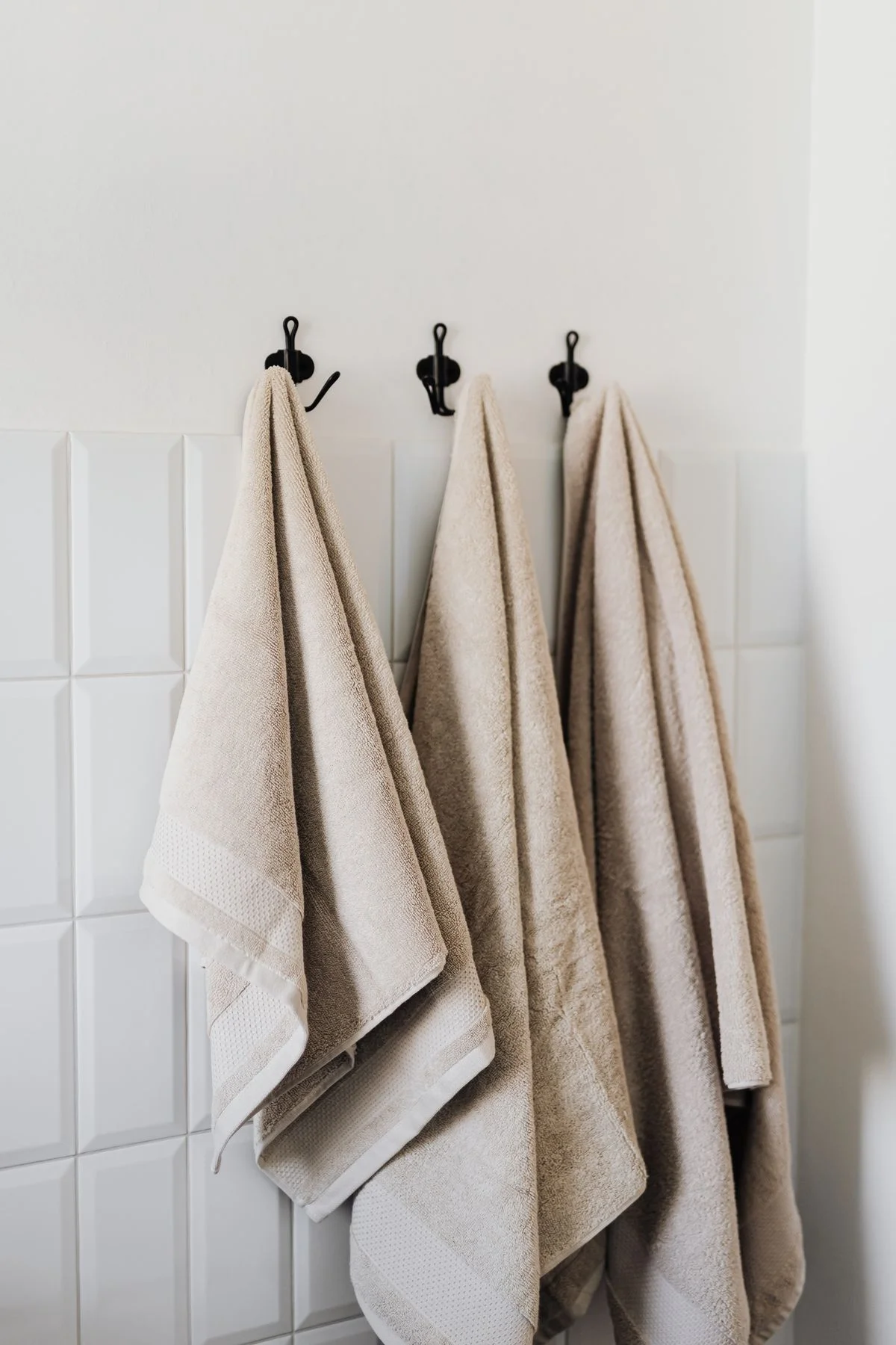Row of towel hooks beside a shower