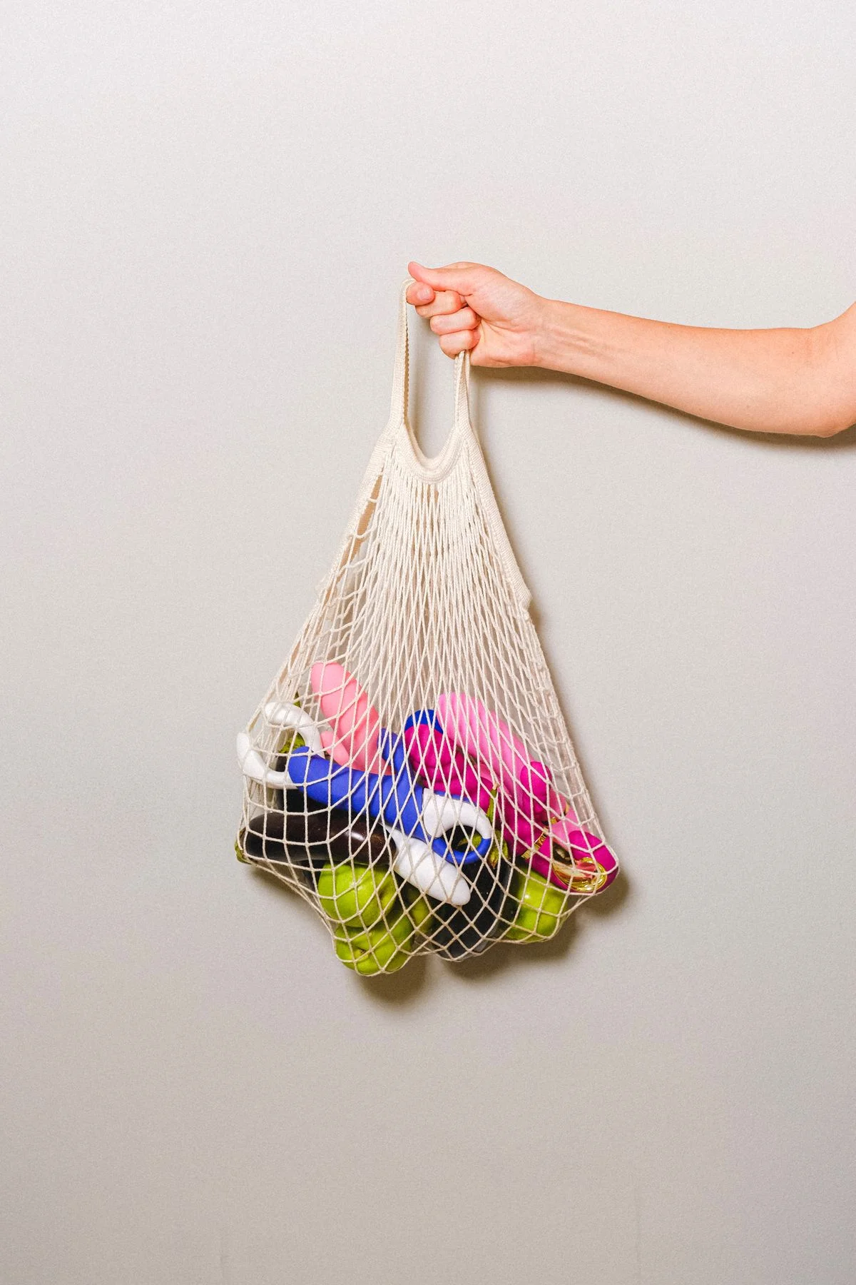Mesh bag holding bath toys hanging in a shower