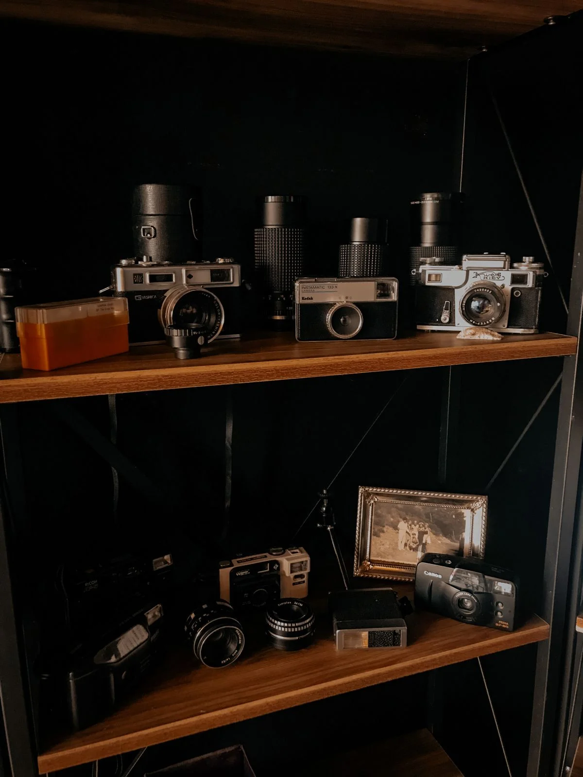 Vintage cameras displayed as collectibles on an office bookshelf