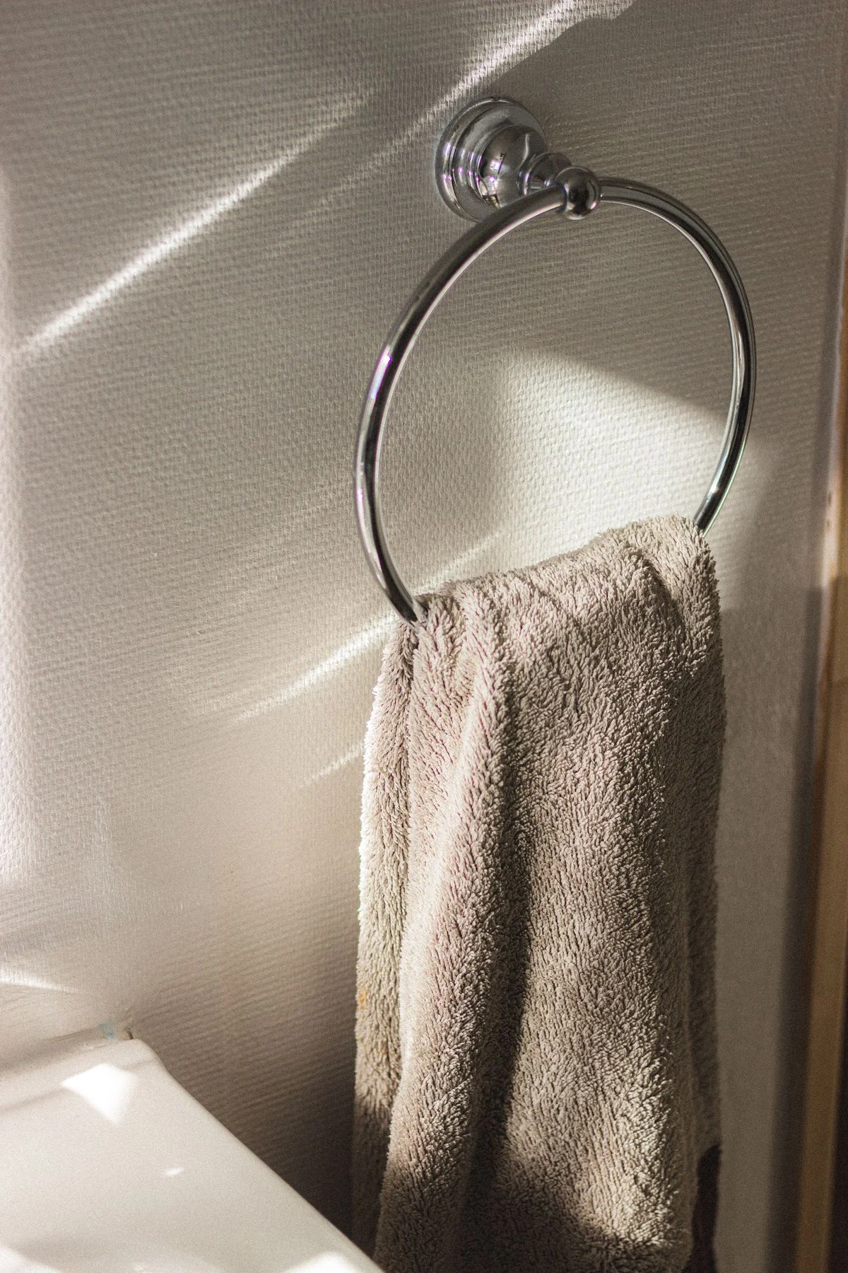 Towel ring mounted on the side of a bathroom vanity
