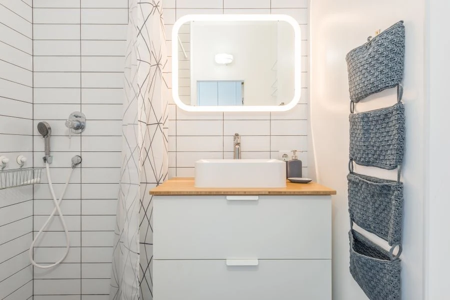 Shower curtain pocket organizer with toiletries hanging in a bathroom
