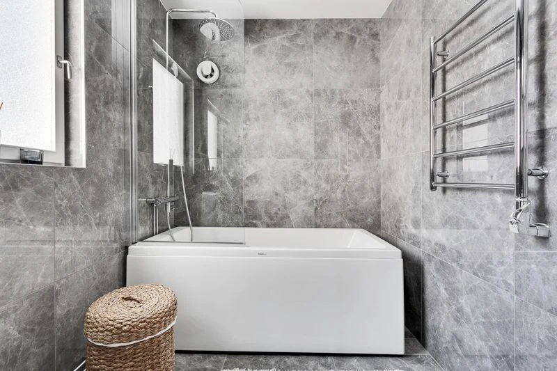 Large basket with towels beside a bathtub